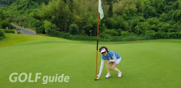 김명진 씨가 홀인원한 볼을 홀에서 집어 내고 있다