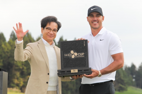 브룩스 켑카와 함께 우승 트로피를 들고 포즈를 취한 이재현 CJ그룹 회장(사진 제공 : JNA GOLF)